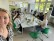 Die Lehrerin macht ein Selfie von sich und den Schüler und Schülerinnen am Frühstückstisch der Schulküche.