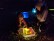 Ein Kind hockt im Dunkeln vor einer Lichterbox und malt darauf. 