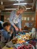 EIne Frau und ein Kind stehen an einem Buffet mit Obst und Brötchen