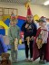 3 Kinder mit Steckenpferden und spitzen Hüten sowie Ritterhelm