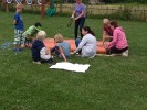 Kinder bauen aus Seilen und Regenrohren ein Floß auf der Wiese