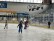 1 Lehrer und 5 Schüler*innen fahren in einer recht leeren Halle Schlittschuh