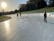 3 Schüler*innen fahren draußen auf einer funkelnden Eisbahn