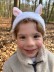 Ein Junge im Wald mit einem Haarreif. Dieser zeigt Ohren eines Hasen.