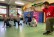 Ein Tanzlehrer und mehrere Kinder tanzen in einer kleinen Turnhalle.