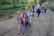 Kinder wandern auf einem Weg durch den Wald.