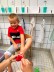 einem Jungen werden die Füße rot angemalt für einen Fußabdruck