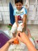 einem Jungen werden die Füße orange angemalt für einen Fußabdruck