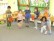 Sechs Kinder spielen die Geschichte mit Pappfrüchten in der Hand nach.