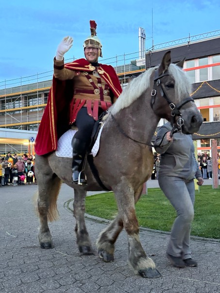 St. Martin wird auf einem Pferd geführt und winkt