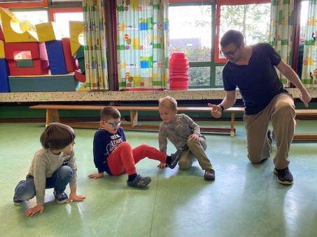 Drei Kinder üben Bewegungen mit einem Tanzpädagogen.