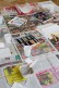 Man sieht einen mit Zeitungspapier ausgelegten Tisch. Auf ihm liegen Pastellkreiden, ein Sieb, Wasserbecher und Papier.