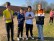 Vier Jugendliche stehen in Sportkleidung auf einem Fußballplatz