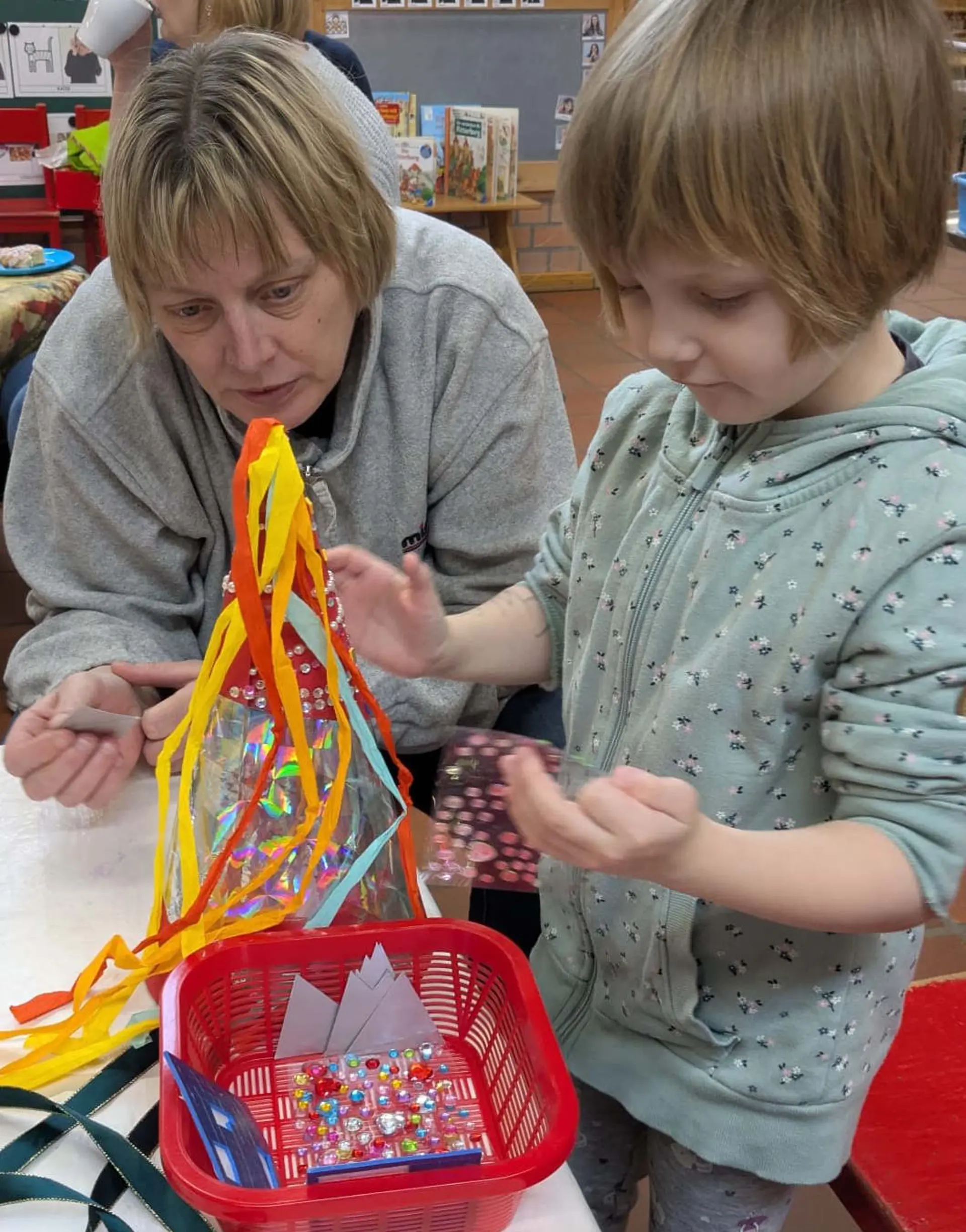 Kind bastelt zusammen mit Lehrkraft