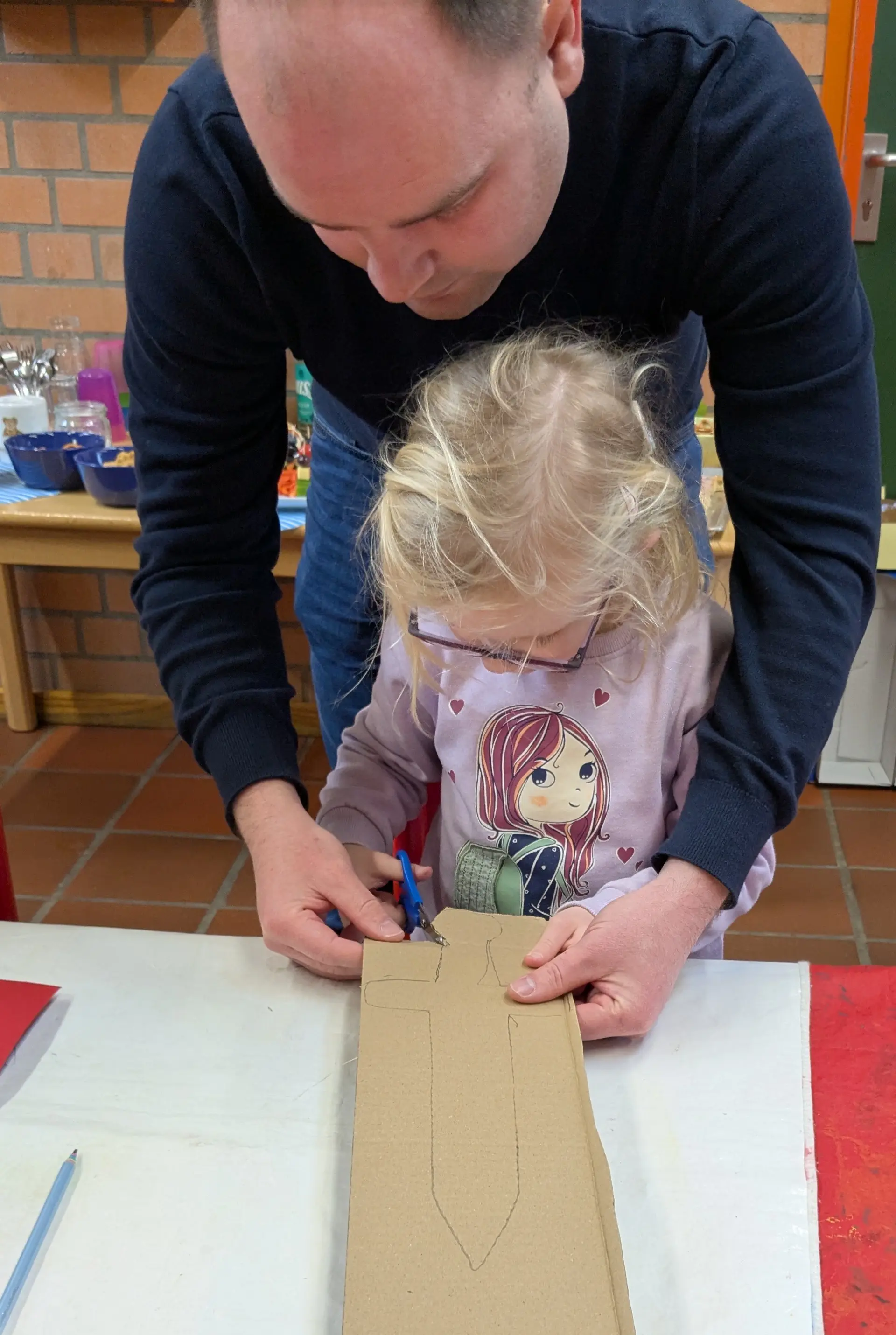 Kind bastelt mit Mann zusammen ein Schwert 