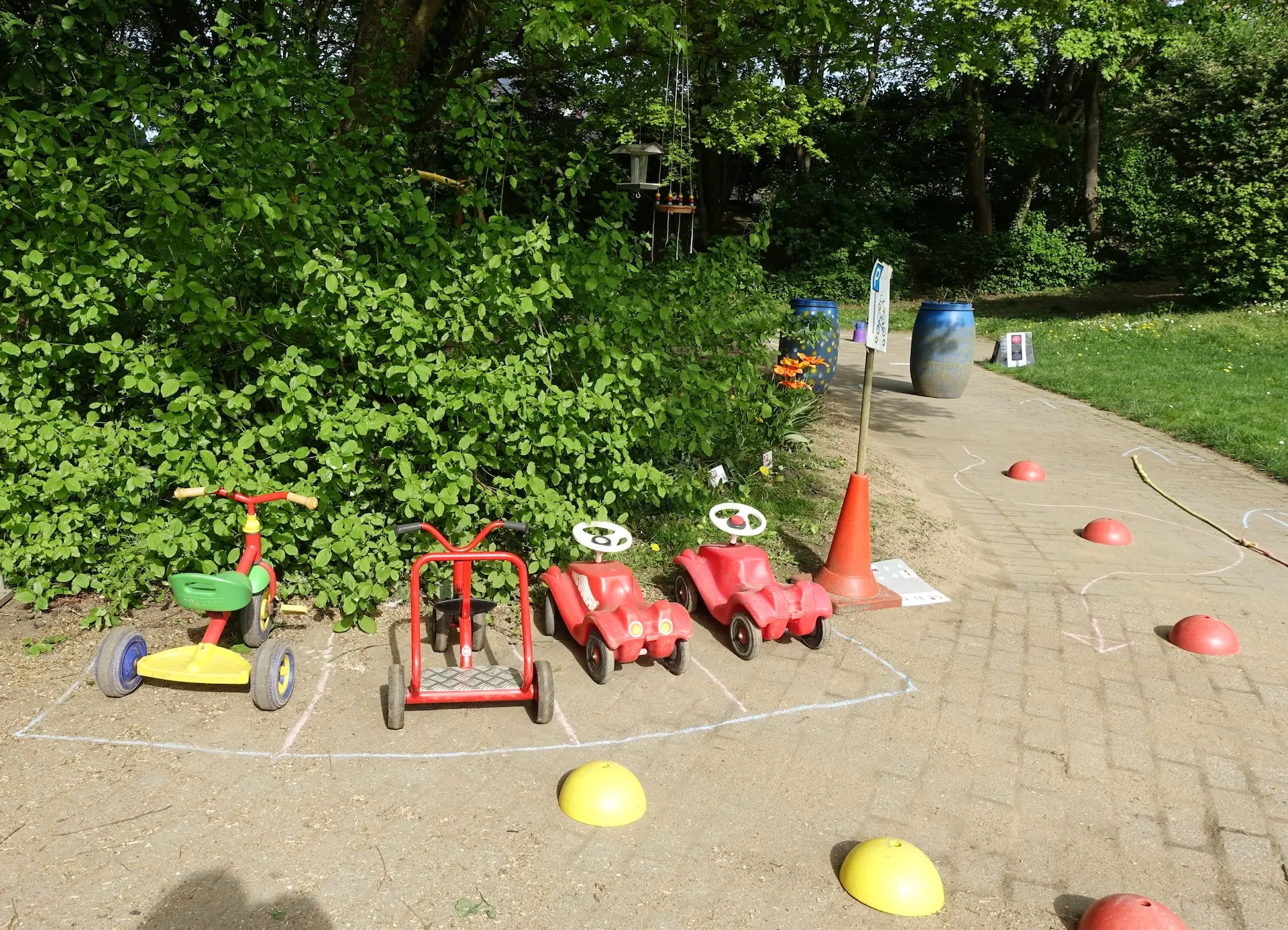 Verschiedene Fahrzeuge für Kinder stehen draußen bereit