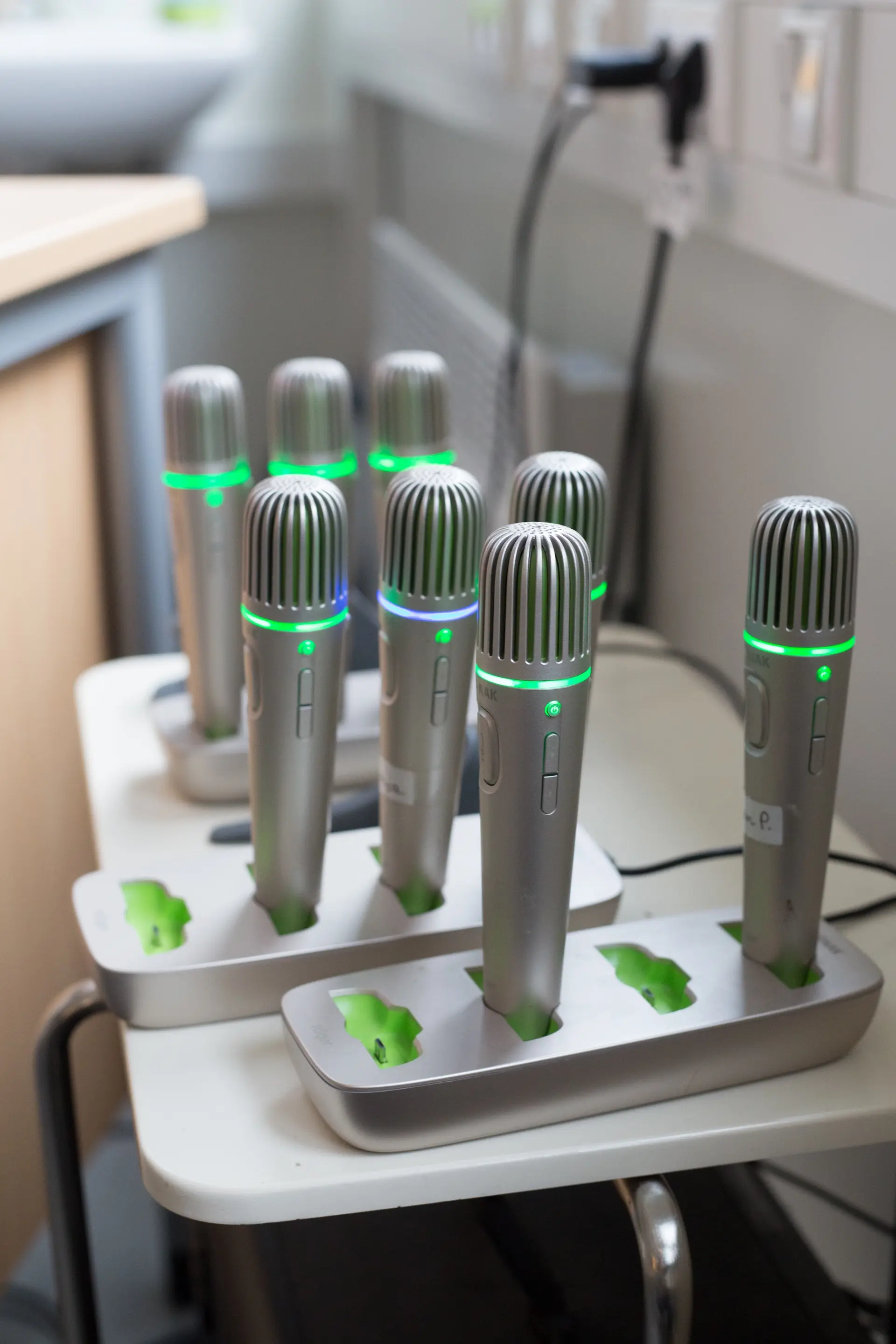 Mehrere Handmikrofone stehen in der Ladestation