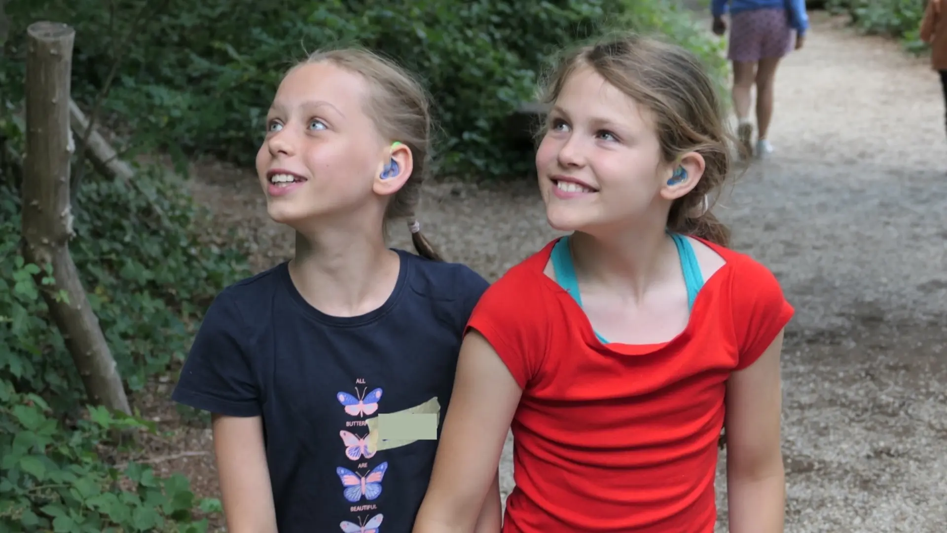 Zwei Kinder im vertrauten Umgang miteinander gehen gemeinsam einen Weg entlang