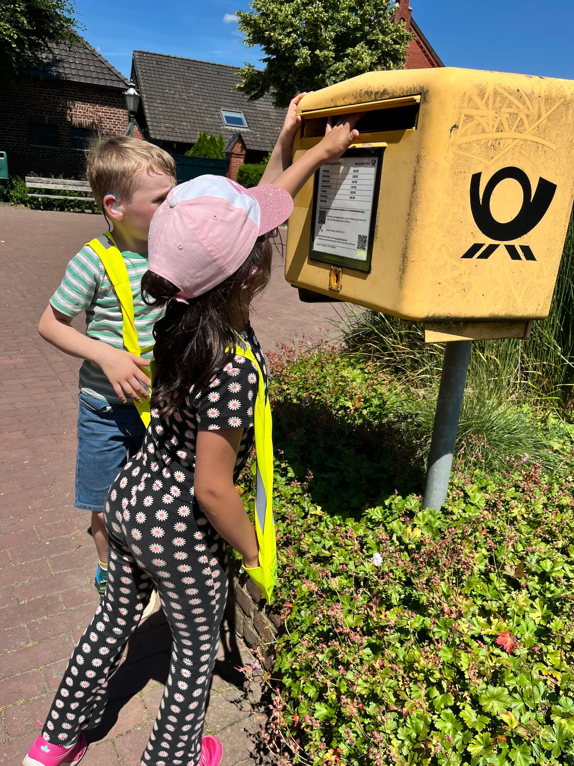 Kinder werfen etwas in einen Briefkasten