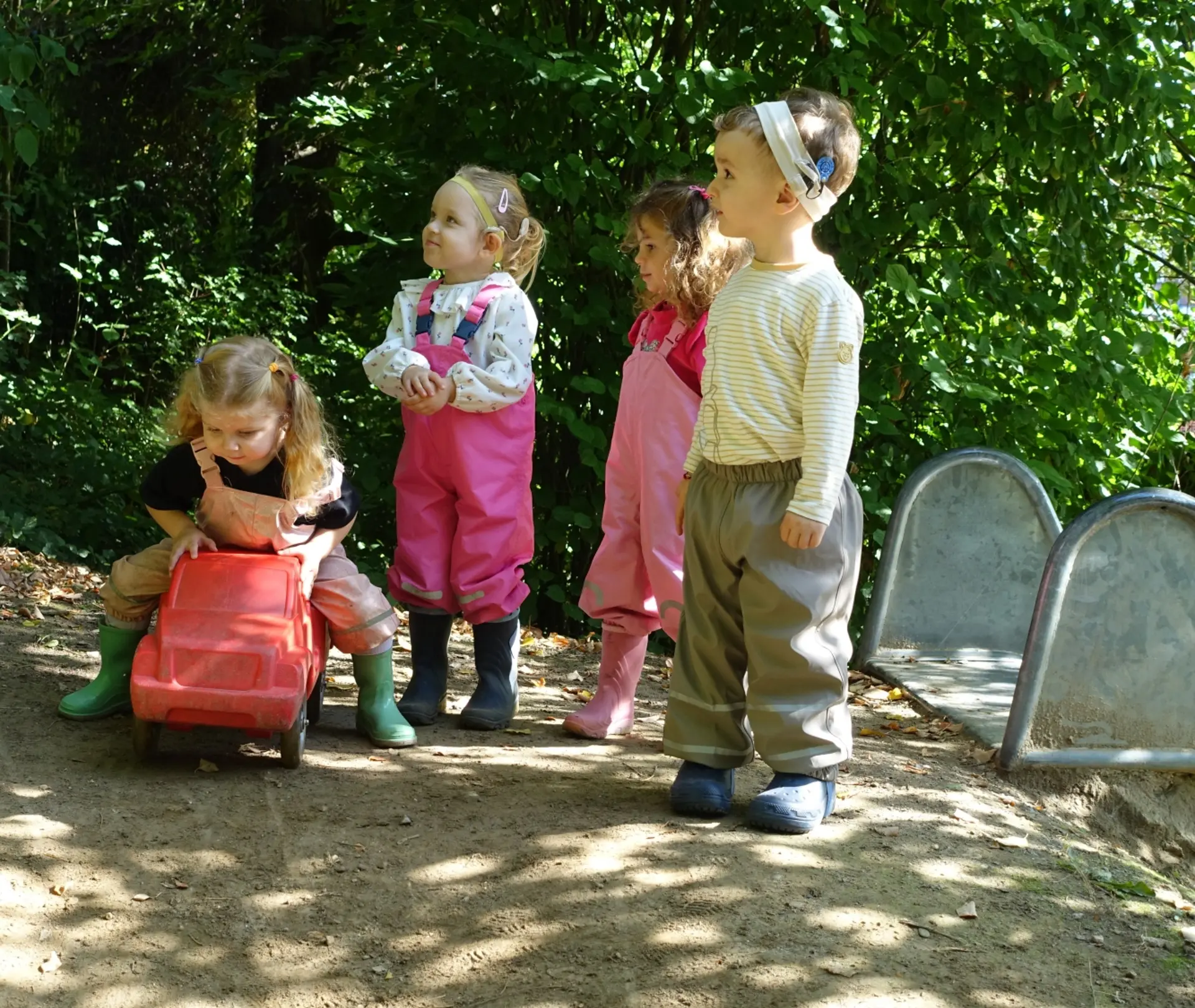Mehrere Kindergartenkinder spielen draußen auf dem Gelände