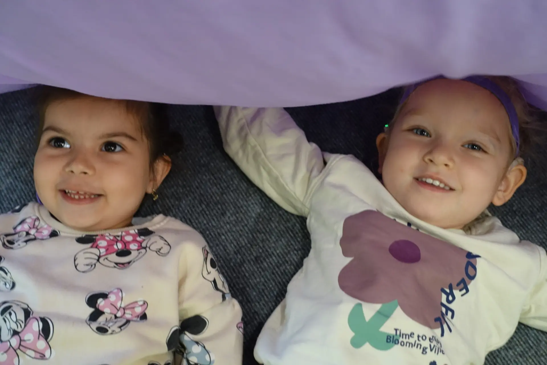 Zwei Kinder verstecken sich unter einer Decke