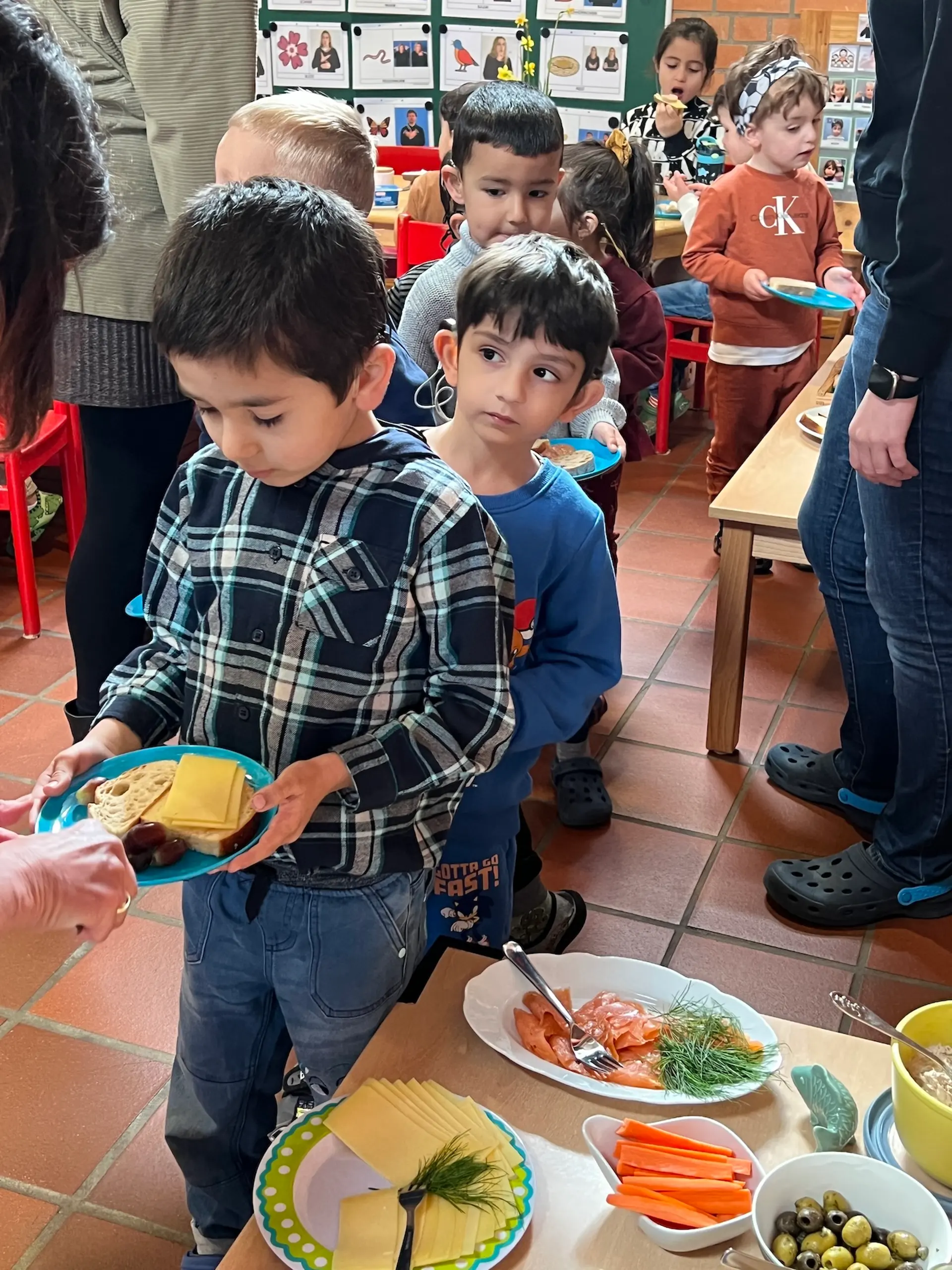 Kinder stehen in einer Schlange am Buffet an