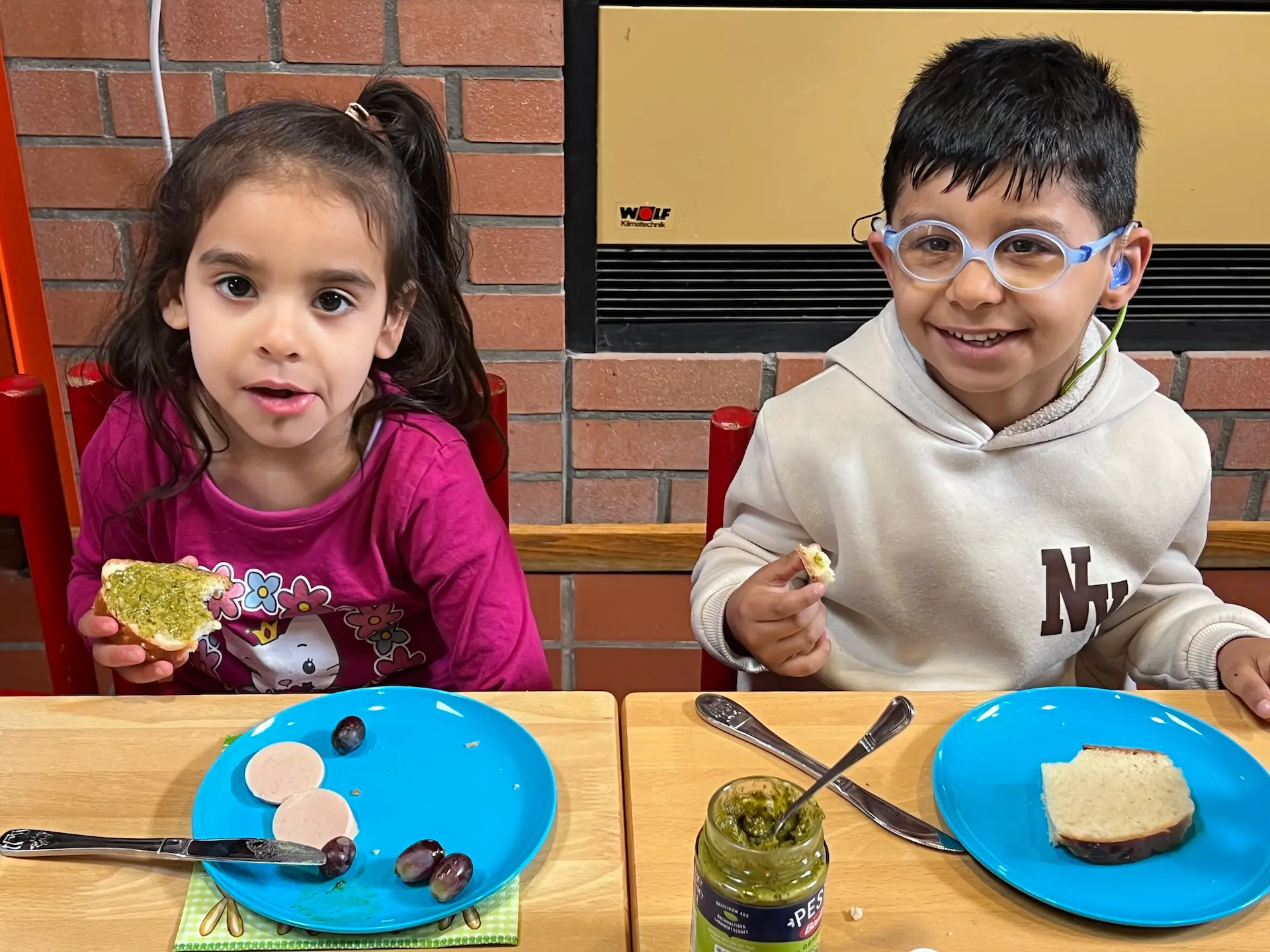 Zwei Kinder sitzen am Tisch und frühstücken