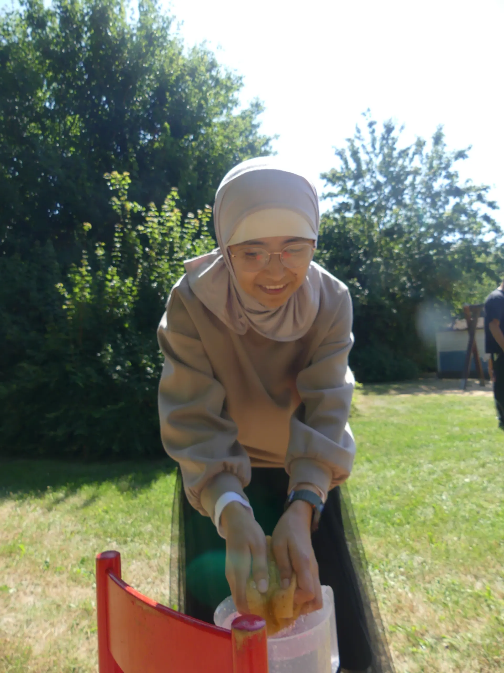 Eine Frau transportiert Wasser mit einem Schwamm