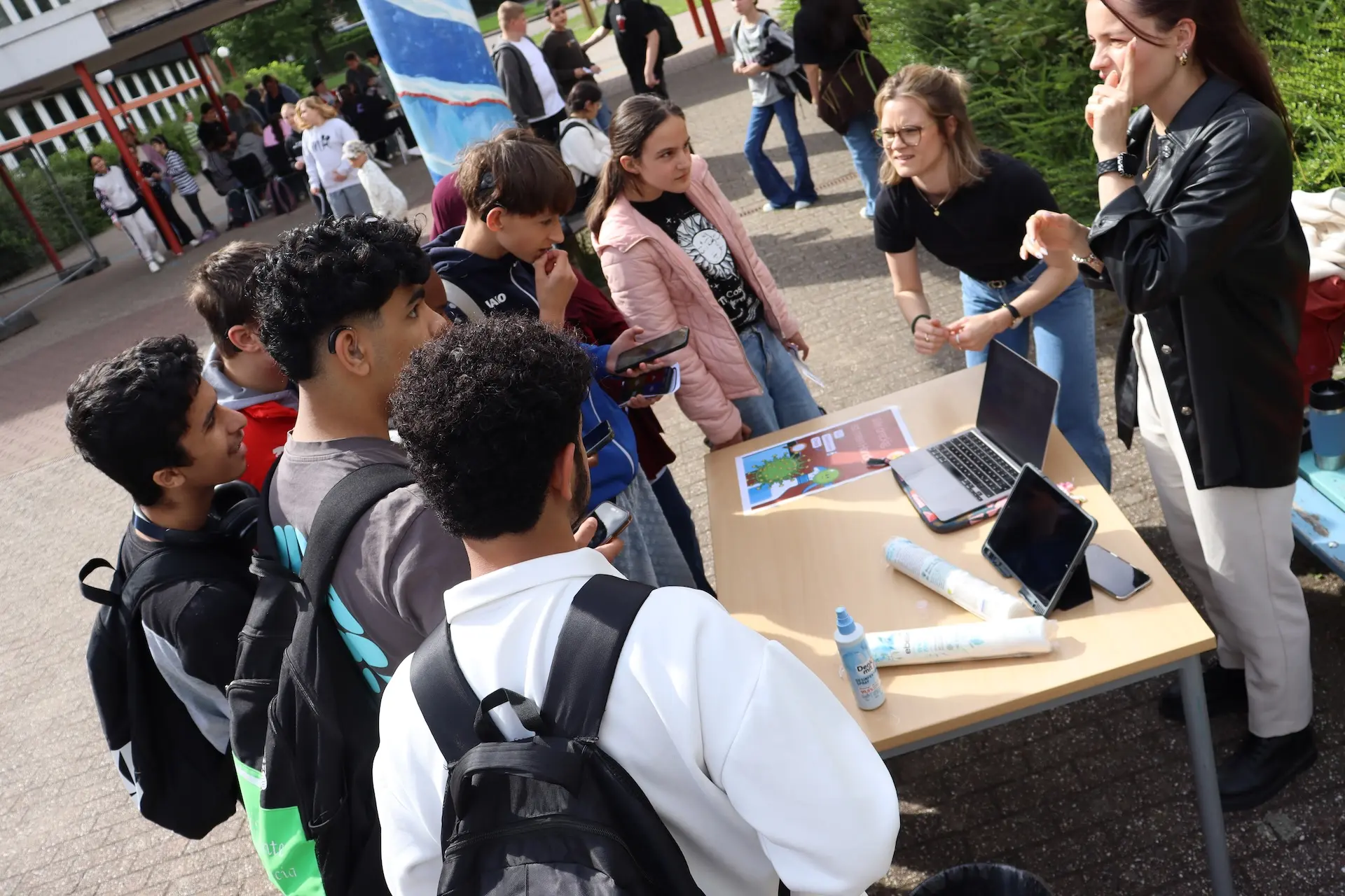 Schüler*innen stehen an einem Infostand auf dem Schulhof
