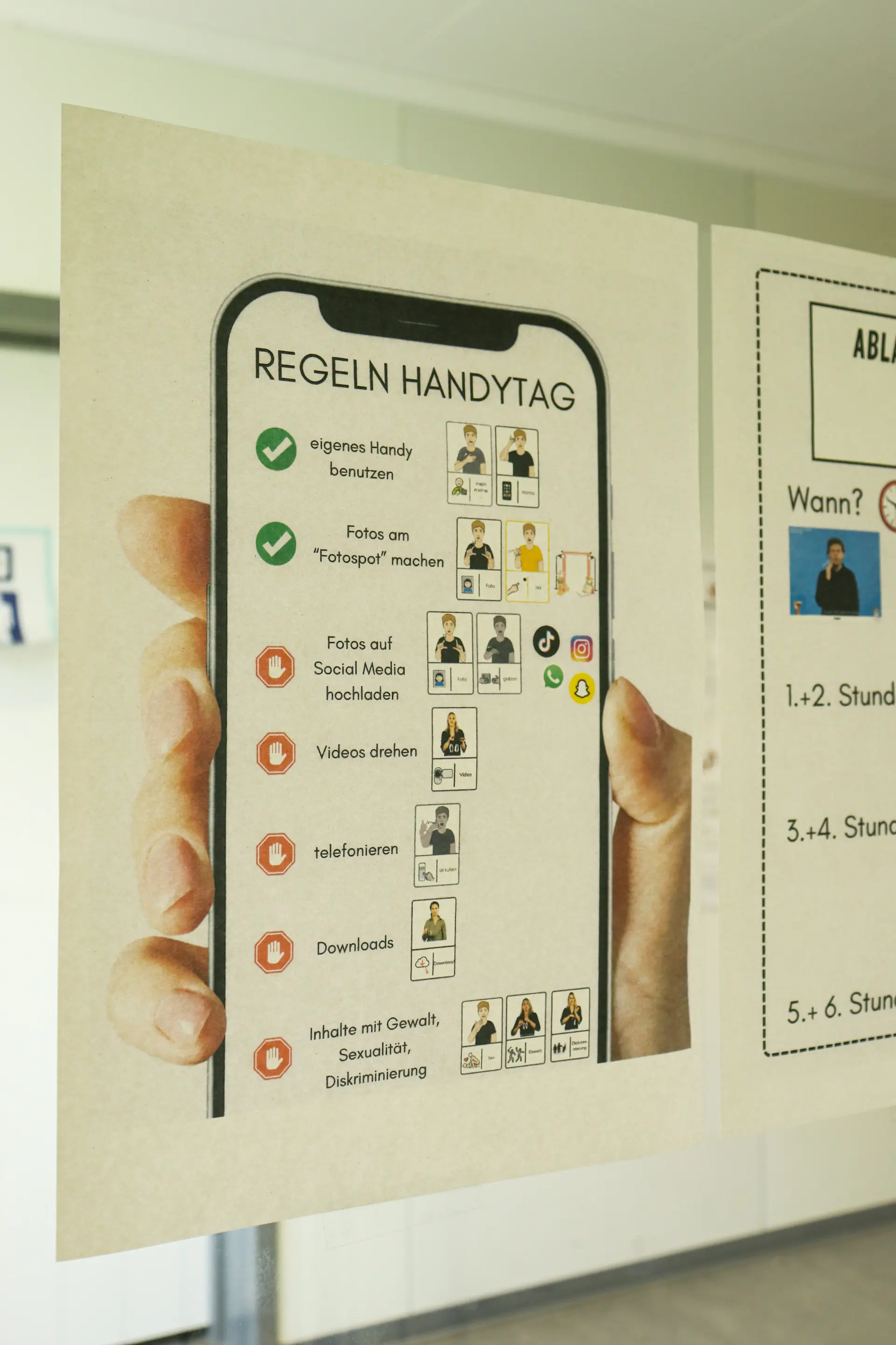Die Regeln zum Handytag hängen an einer Glastür