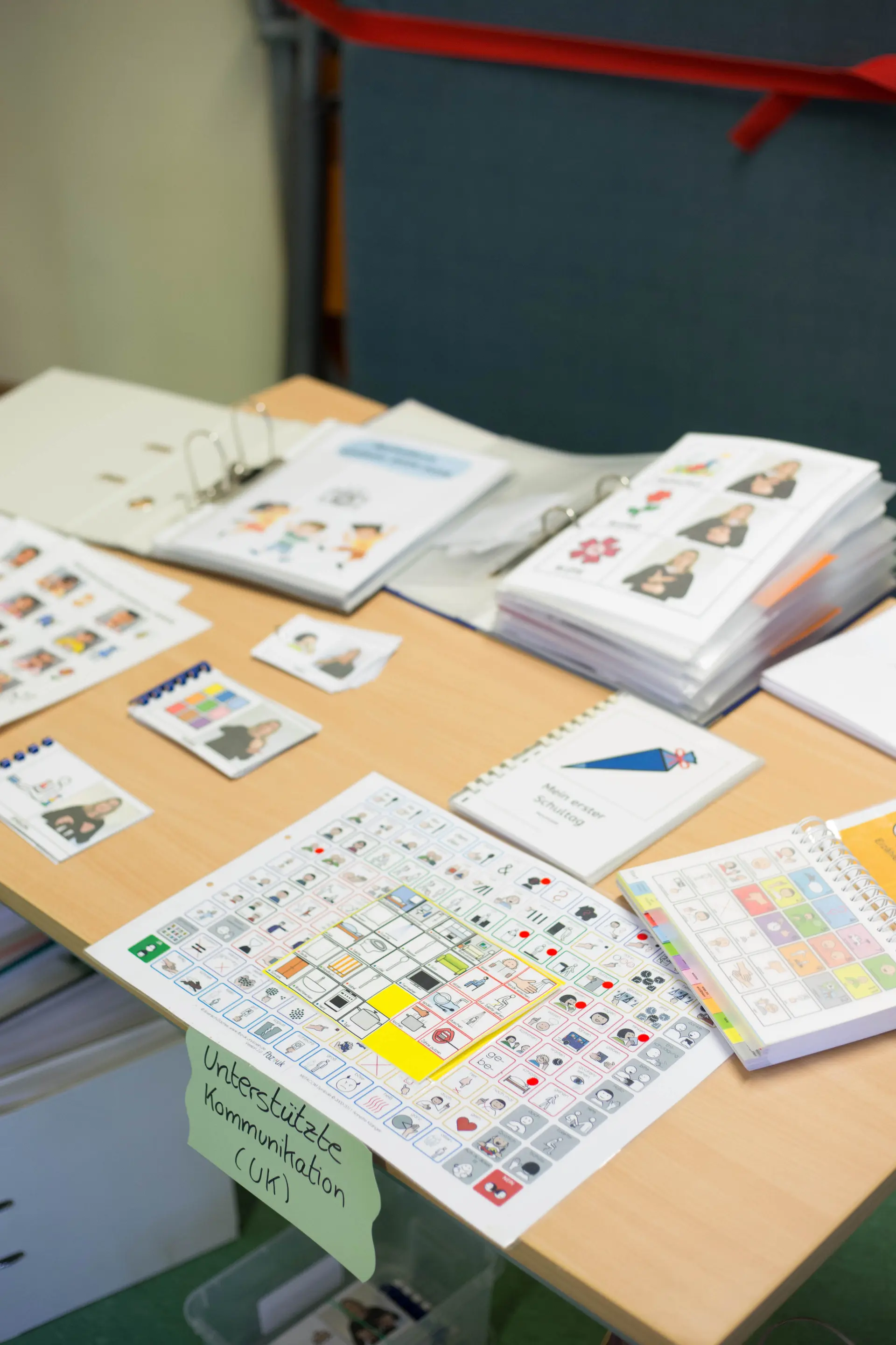 Auf einem Tisch liegen Materialien zum Thema Unterstütze Kommunikation
