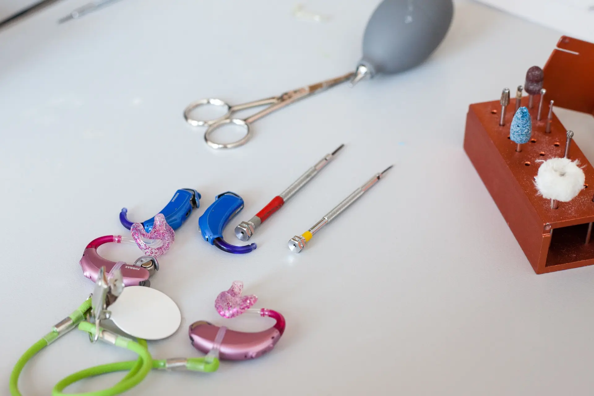 Kinder-Hörsysteme und Werkzeuge des Pädakustikers sind auf dem Tisch ausgebreitet