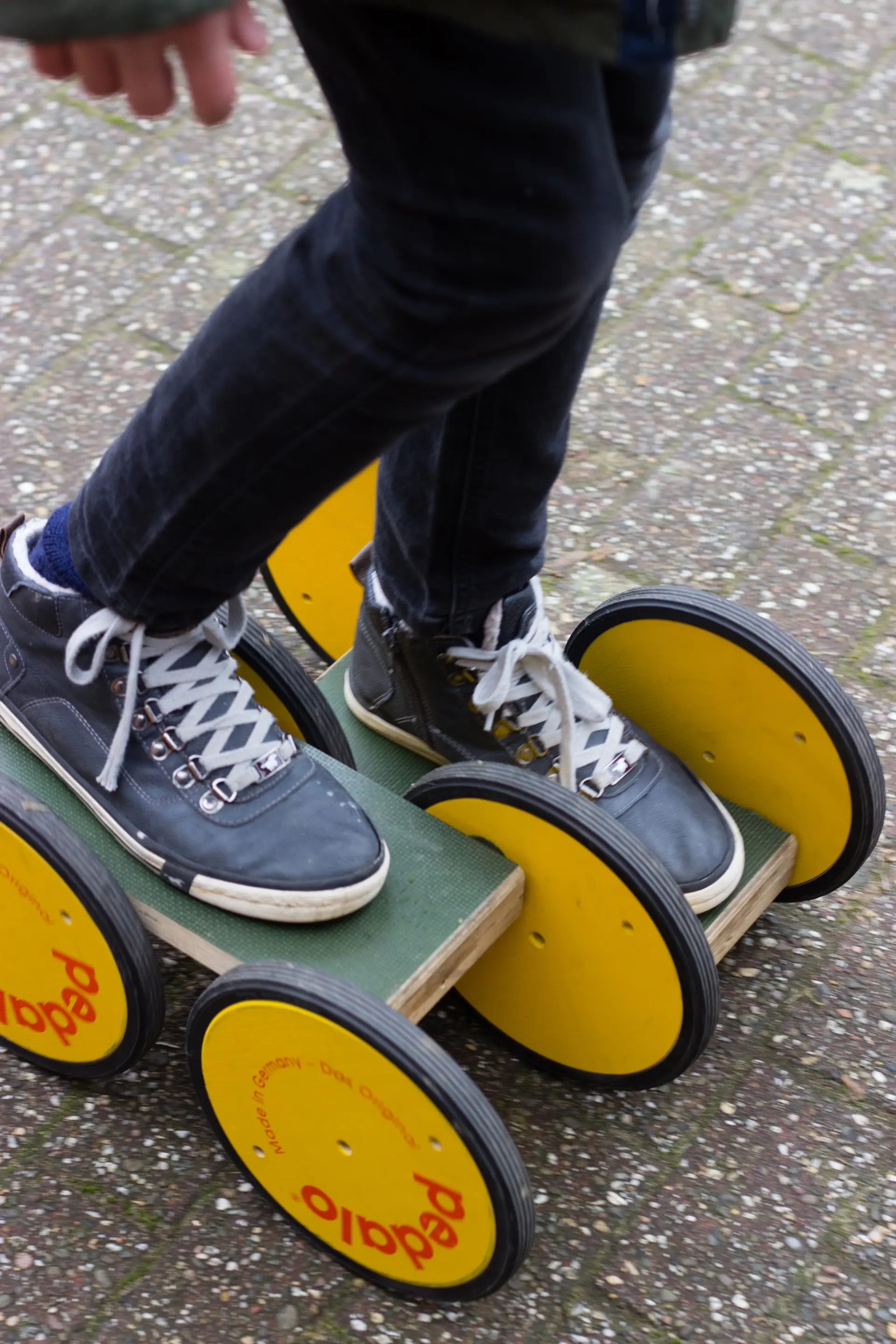 Kind fährt mit einem Pedalo auf dem Schulhof
