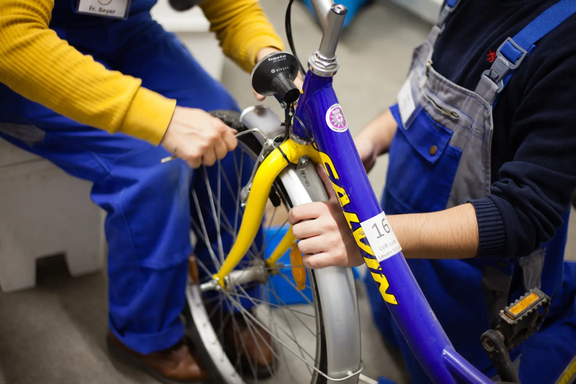 Kinder arbeiten in der Fahrradwerkstatt an einem Rad