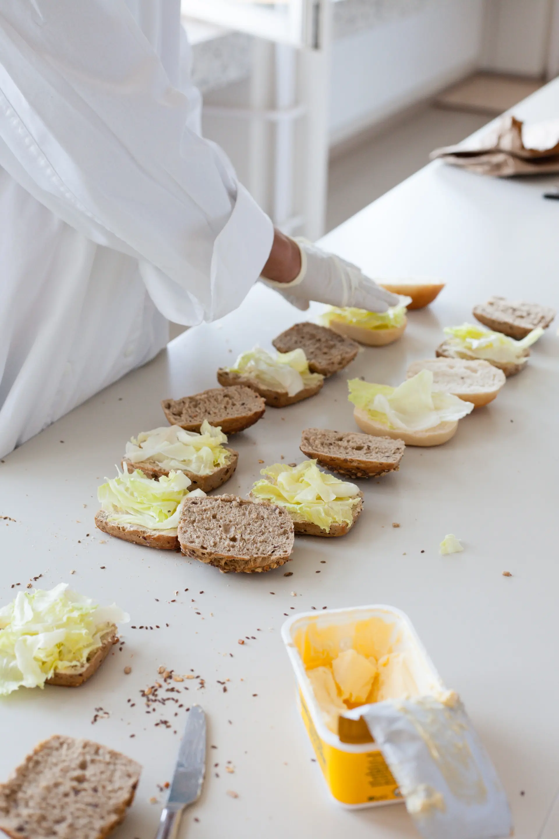 Kinder bei der Zubereitung von Brötchen mit Salat