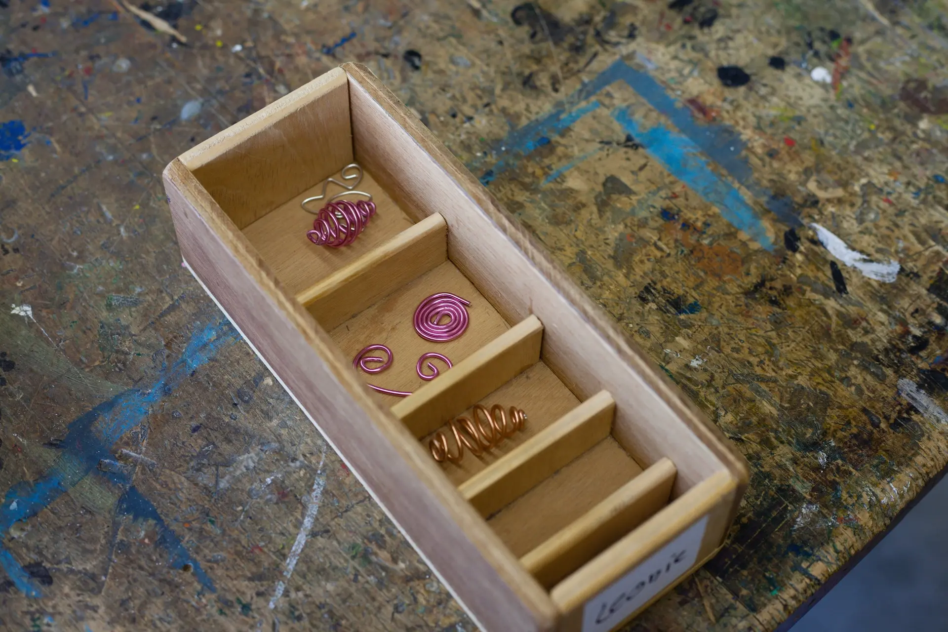 Kiste mit Schmuckstücken, die aus buntem Draht gefertigt wurden